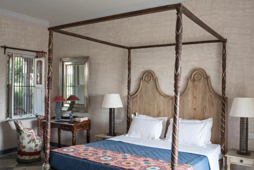 乌代浦Bujera Fort的一间卧室配有一张带蓝色棉被的天蓬床