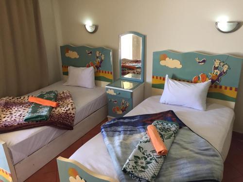 艾因苏赫纳Chalets in Porto Sokhna - Pyramids - Families Only的儿童卧室内的两张床,里面饲养着动物