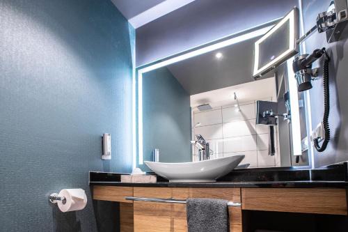 勒沃库森Leoso Hotel Leverkusen的一间带水槽和大镜子的浴室