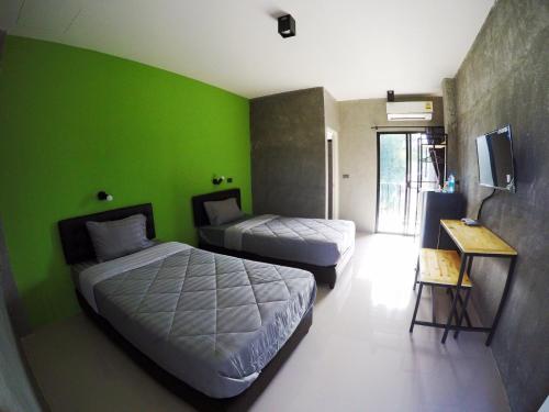 Ban Muak LekRimnamresidence的一间设有两张床和绿色墙壁的客房