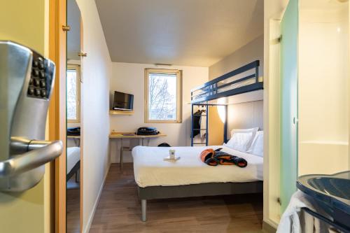 布雷斯地区布尔格布雷斯布尔格宜必思快捷酒店的一间卧室,配有一张带一对护目镜的床
