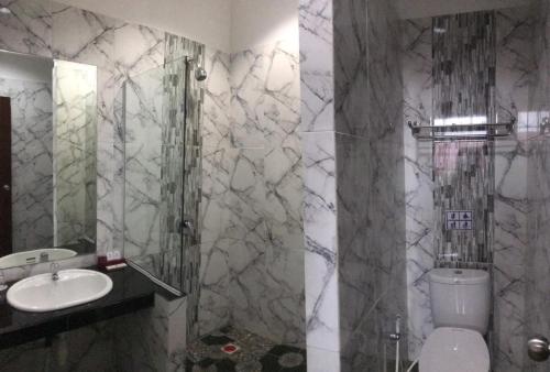 坤甸哈默尼酒店和卡拉OK的一间带水槽、淋浴和卫生间的浴室