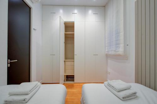 马德里Luxury Rooms Madrid Center的白色墙壁客房的两张床