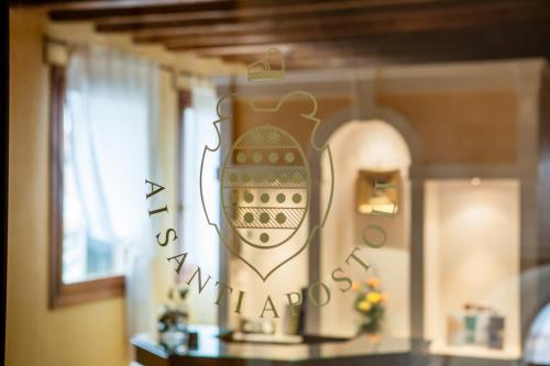 威尼斯罗坎达爱桑蒂阿帕斯托利酒店的桌子上方有花瓶的墙