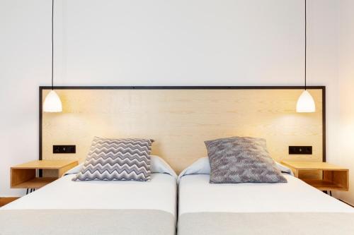 巴塞罗那费南多旅馆的一间卧室配有一张大床和两个枕头