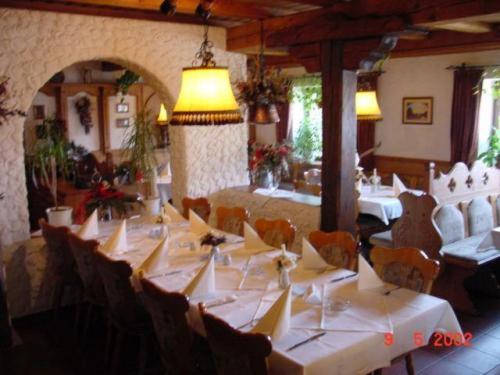 Scheinfeld施若特姆莱餐厅酒店的一间设有白色桌椅和灯光的用餐室