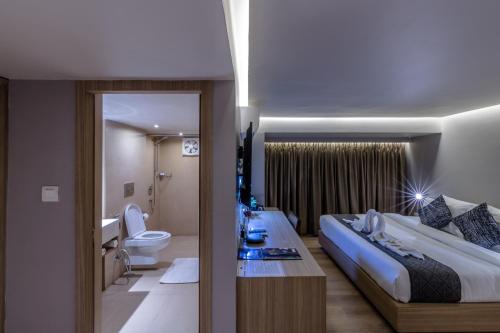 加尔各答Princeton Club的酒店客房设有一张大床和一间浴室。