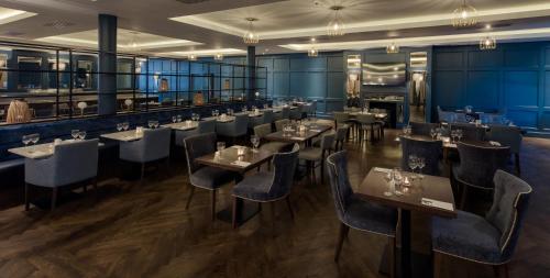 沃特福德沃特福德维京酒店的餐厅拥有蓝色的墙壁和桌椅