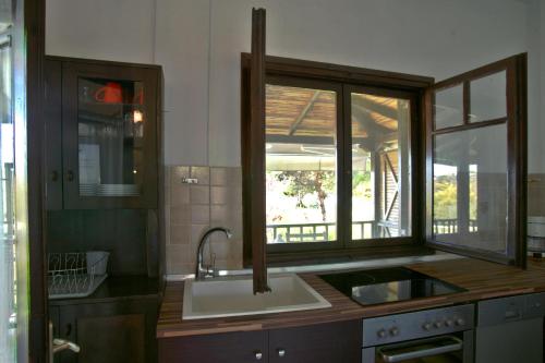 奥马斯帕纳吉亚斯Lagonisi Beach Resort的厨房设有水槽和窗户。