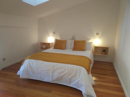 布尔戈斯La casa de LA FLORA a 3 minutos de la catedral VUT09187的卧室配有带橙色枕头的大型白色床
