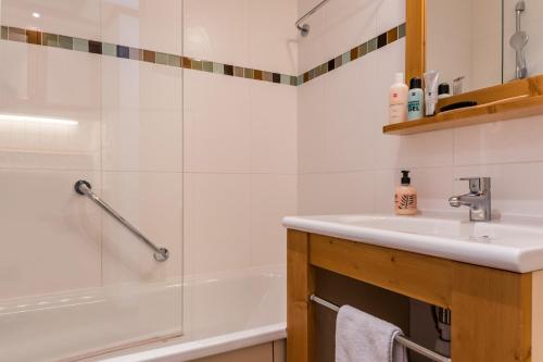 谷雪维尔Résidence Pierre & Vacances le Moriond的浴室配有盥洗盆和浴缸。