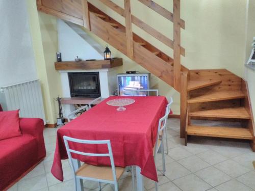 AviaticoLA CASA DEL BORGO的一间带红色桌子和楼梯的用餐室