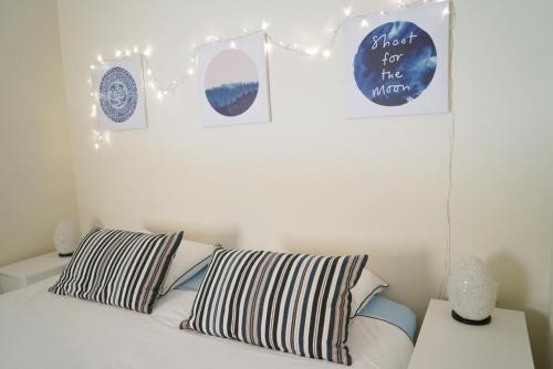 吉亚德伊索拉Balcón del Mar - Playa San Juan的一间卧室配有一张带枕头的床,墙上挂有图片