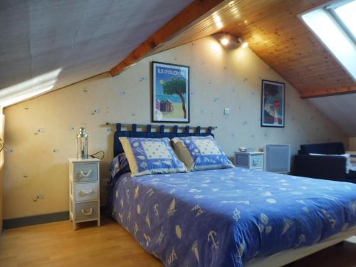 弗内Les Aubretias的一间卧室配有一张带蓝色棉被的床