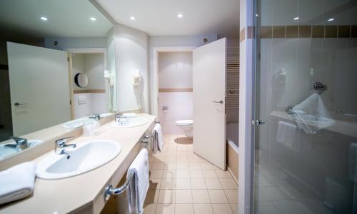 布兰肯贝赫Hotel Aazaert by WP Hotels的一间带两个盥洗盆和淋浴的浴室