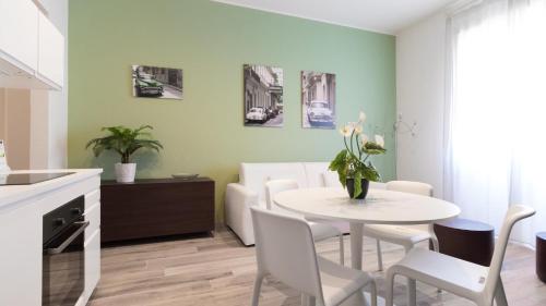 米兰Italianway - Merlo 3的厨房以及带白色桌椅的用餐室。