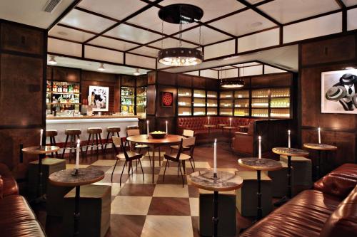 纽约Gild Hall, A Thompson Hotel, by Hyatt的一间带桌椅的餐厅和一间酒吧