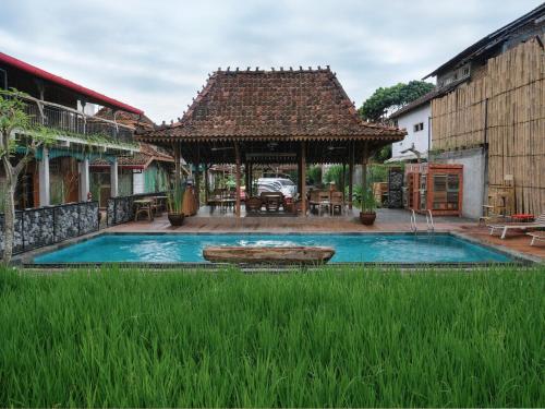 日惹Kampung Lawasan Heritage Cottage的一座带游泳池和凉亭的房子