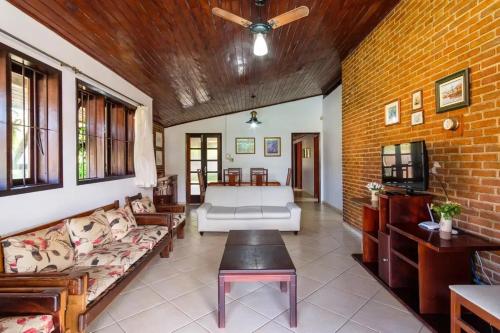 乌巴图巴BEST HOUSES 4: CASA COM PISCINA NA PRAIA GRANDE的带沙发和砖墙的客厅