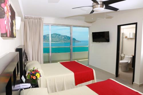 马萨特兰拉斯弗洛雷斯海滩度假村酒店的一间卧室配有一张床,享有海景