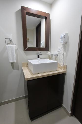 马萨特兰拉斯弗洛雷斯海滩度假村酒店的浴室设有白色水槽和镜子