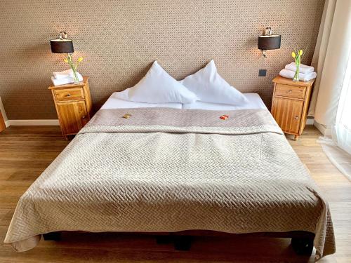 杜伊斯堡Hotel Akazienhof的一间卧室配有一张带2个床头柜的大床