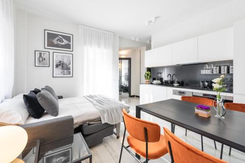 维罗纳A World Aparts - 12 Viviani的厨房以及带床和桌子的客厅。