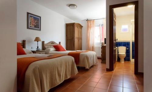 NohalesHabitaciones Casa Rural El Sauce的酒店客房带两张床和一间浴室