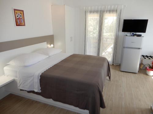 扎达尔Apartments Simicev的一间卧室配有一张大床和电视