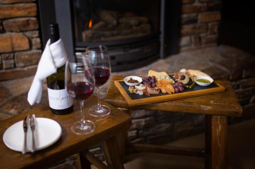 皇后镇Hidden Lodge Queenstown的一张桌子,上面放着一盘食物和一瓶葡萄酒