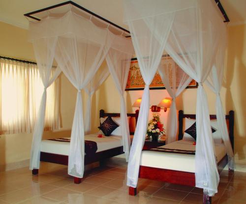 罗威那阿奈卡洛维纳别墅及温泉酒店的卧室内的两张床,带白色窗帘