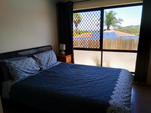 黄金海岸Cosy, self-contained and central to everywhere的一间卧室设有蓝色的床和大窗户