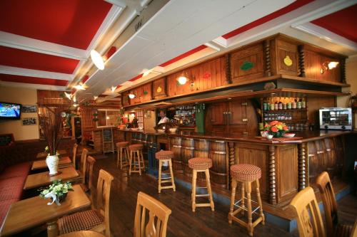 La Haye-du-Puits勒康莫塞酒店的餐厅内的酒吧,设有木桌和凳子