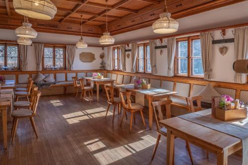 福森阿拉特湖餐厅酒店的餐厅设有木桌、椅子和窗户。