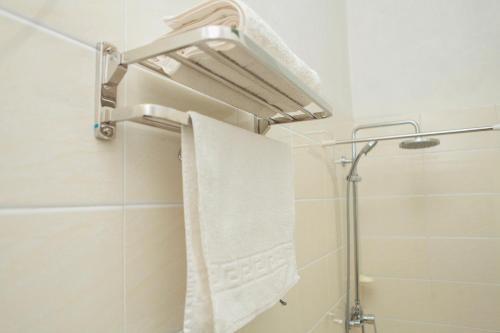 布琼布拉Hotel Kangaroo Bujumbura的带淋浴和白色毛巾的浴室
