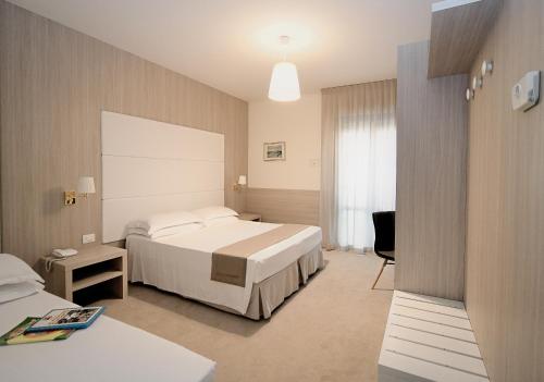 利多迪耶索罗大西洋酒店的配有一张床和一张书桌的酒店客房