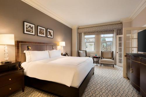 渥太华Fairmont Chateau Laurier Gold Experience的酒店客房设有一张大床和一台电视。
