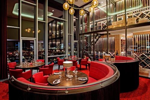 哥本哈根蒂沃里酒店的餐厅内带红色椅子和桌子的酒吧