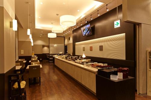 仙台多美迎EXPRESS仙台广瀨通酒店的一间设有长柜台的餐厅,提供自助餐