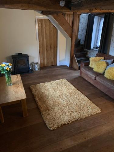 勒德洛The griffin cottage的带沙发和地毯的客厅