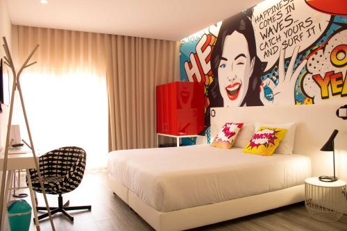 佩尼契RIDE Surf Resort & Spa的卧室配有白色的床和墙上的绘画作品
