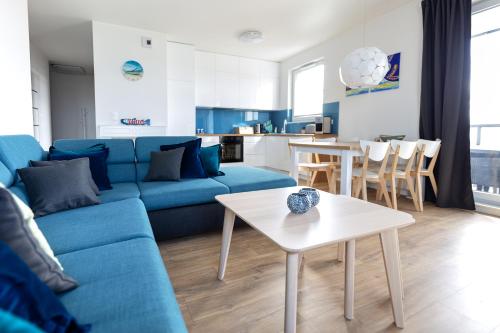 格但斯克波罗的海海滨塔公寓式酒店的客厅配有蓝色的沙发和桌子