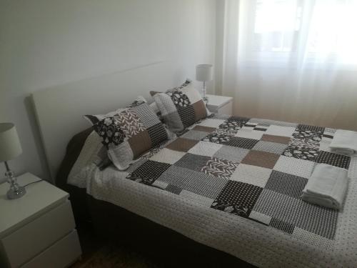阿尔马达Casa do Pedro - Lisbon South Bay的一间卧室配有一张带 ⁇ 子毯子和枕头的床