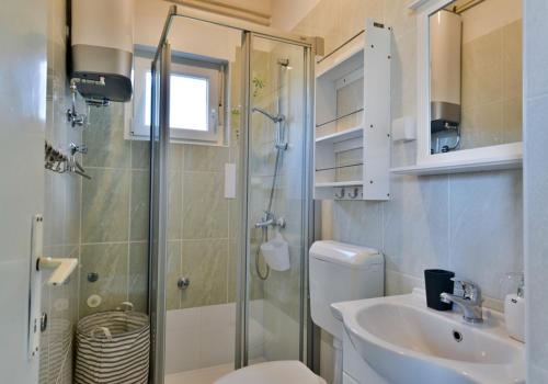 乌马格Seafront Apartment Jadri的带淋浴、卫生间和盥洗盆的浴室