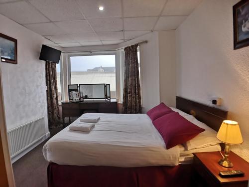 布莱克浦The Hopton Hotel的一间卧室设有一张大床和大窗户