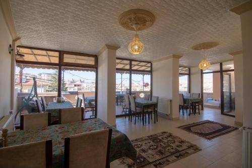 格雷梅Kamelya Cave Hostel的用餐室设有桌椅和窗户。