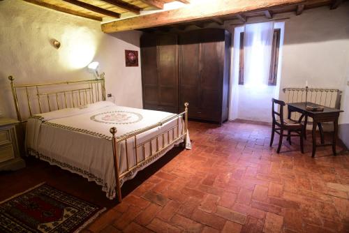维基奥Casa Botena的卧室配有一张床和一张桌子及椅子