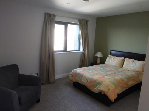 基拉尼Arbutus Lodge的卧室配有床、椅子和窗户。