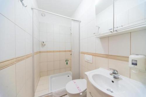 波德戈里察Hotel Piramida的白色的浴室设有卫生间和水槽。