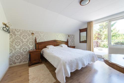 霍恩Bed and Breakfast Hoorn的一间卧室设有一张床和一个大窗户